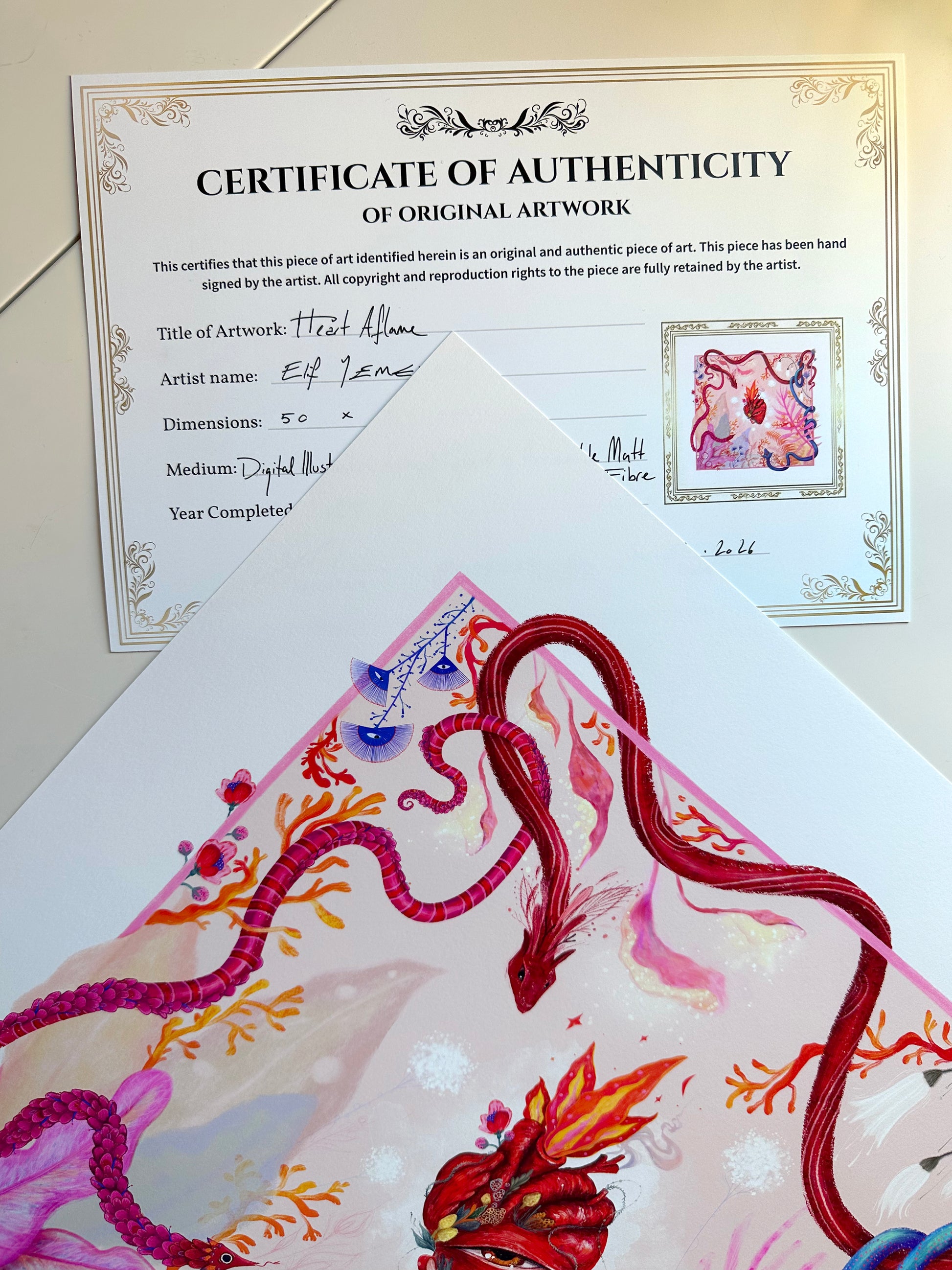 Certificate of Authenticity for the "Heart Aflame" digital illustration by Elif, placed behind the original signed art print.