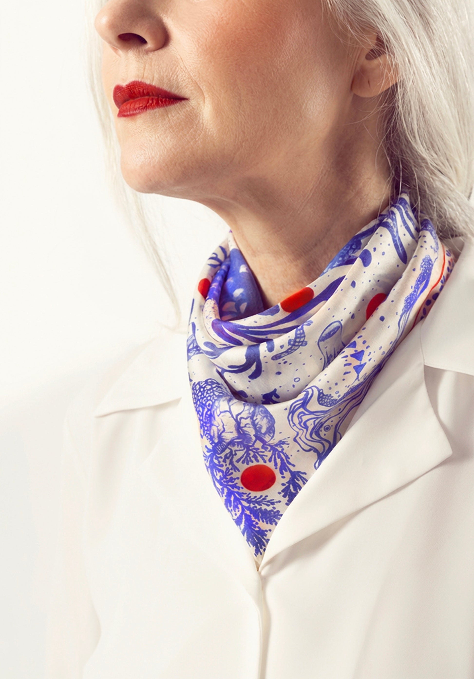 Mavi desenli kare ipek fuların üçgen bağlama stili