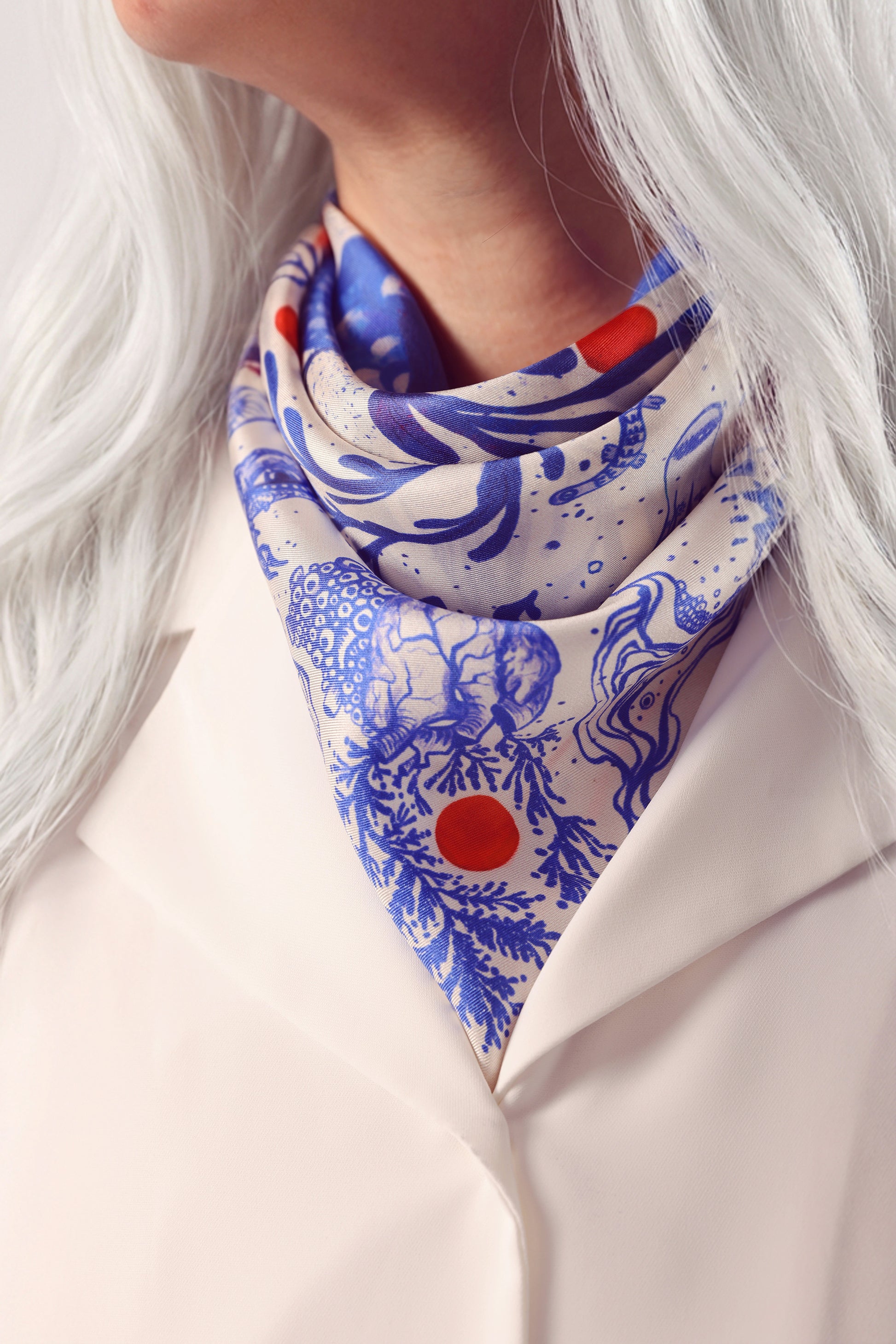 Mavi ve kırmızı desenli ipek twill fuların bağlanmış kullanım şekli