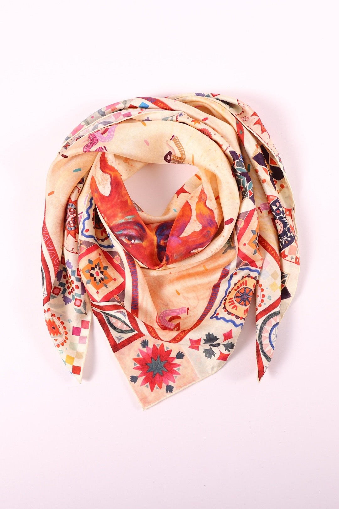 Artistic silk scarf with a colorful sun motif and patterned edges folded on a clean white background.