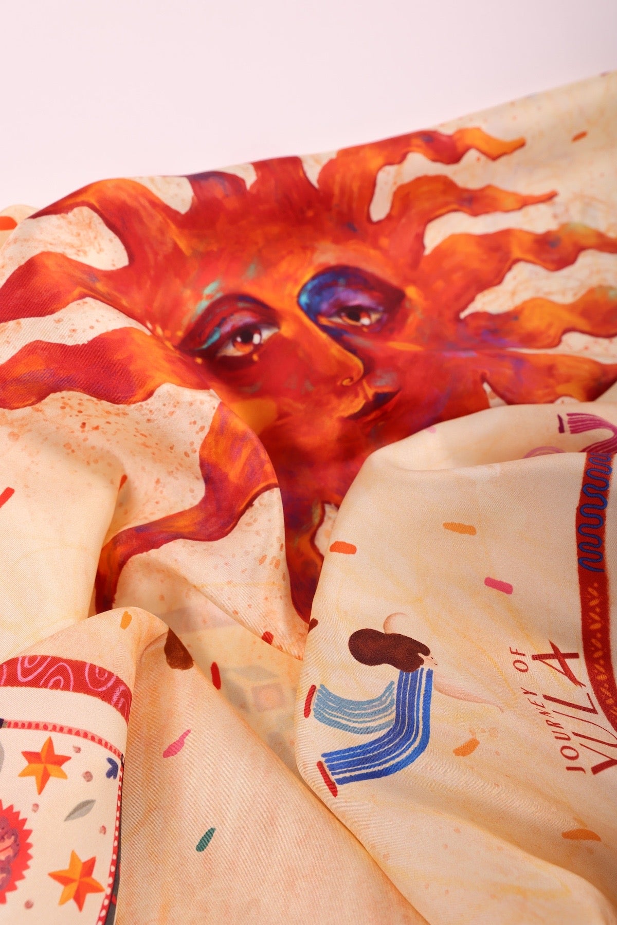 Macro shot of the vibrant sun illustration on soft silk fabric, highlighting the fine artistic details and colors.