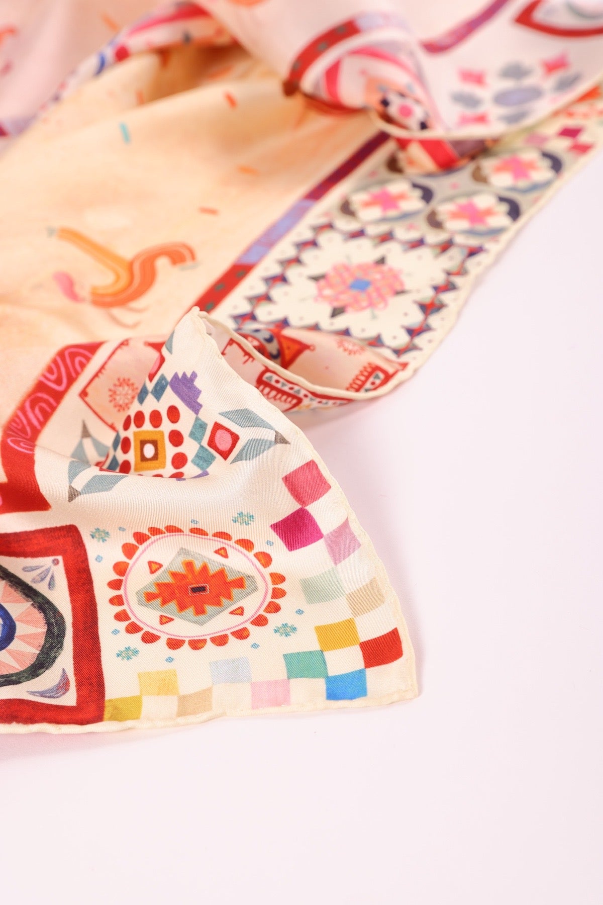 Close-up focus on the intricate geometric border and artisanal patterns of a Journey of Yula designer scarf.