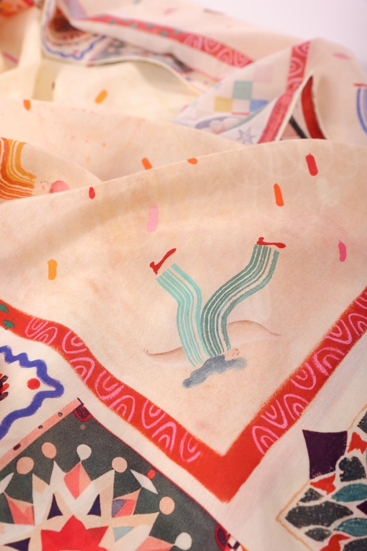 Close-up of a whimsical character illustration on the Journey of Yula wearable art silk collection.