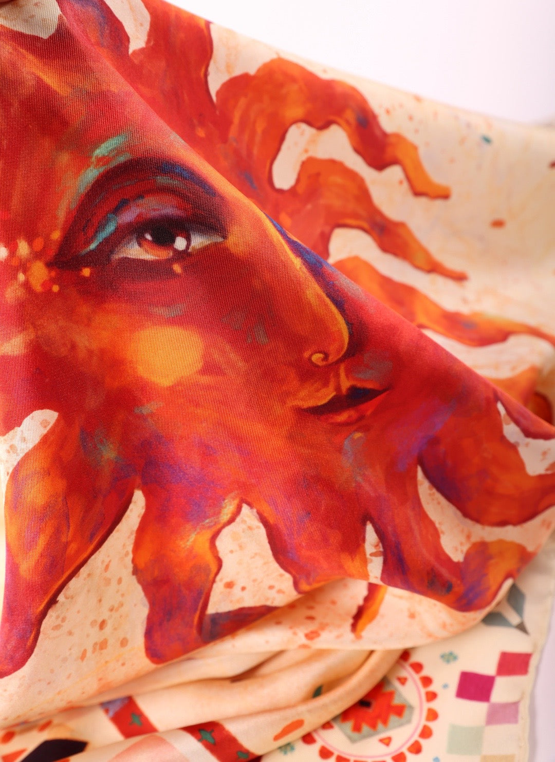Macro shot of the vibrant sun illustration on soft silk fabric, highlighting the fine artistic details and colors.