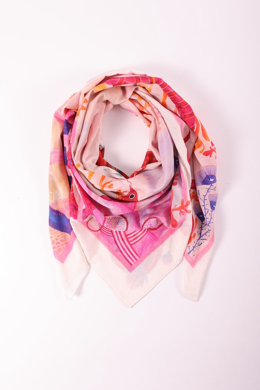 Premium silk scarf with pink and red artistic prints folded artistically on a clean white background.