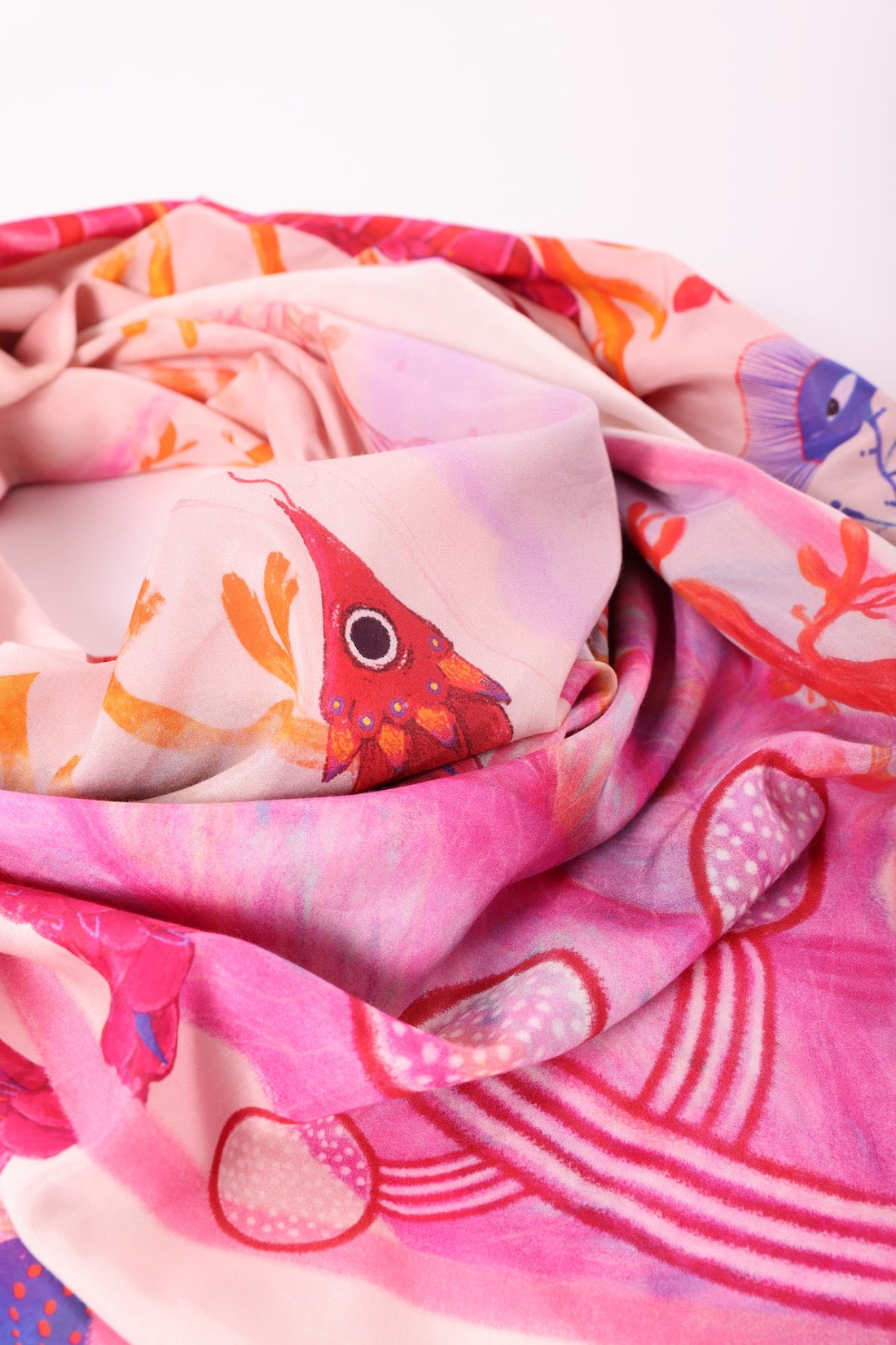 Close-up detail of the fine silk fabric, focusing on a hand-painted red creature and soft pink textures.