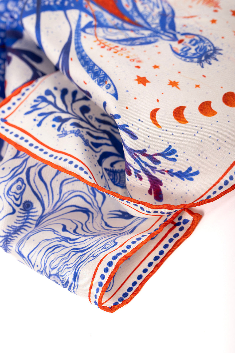 Soft silk fabric texture and hand-rolled edge detail of a luxury scarf.