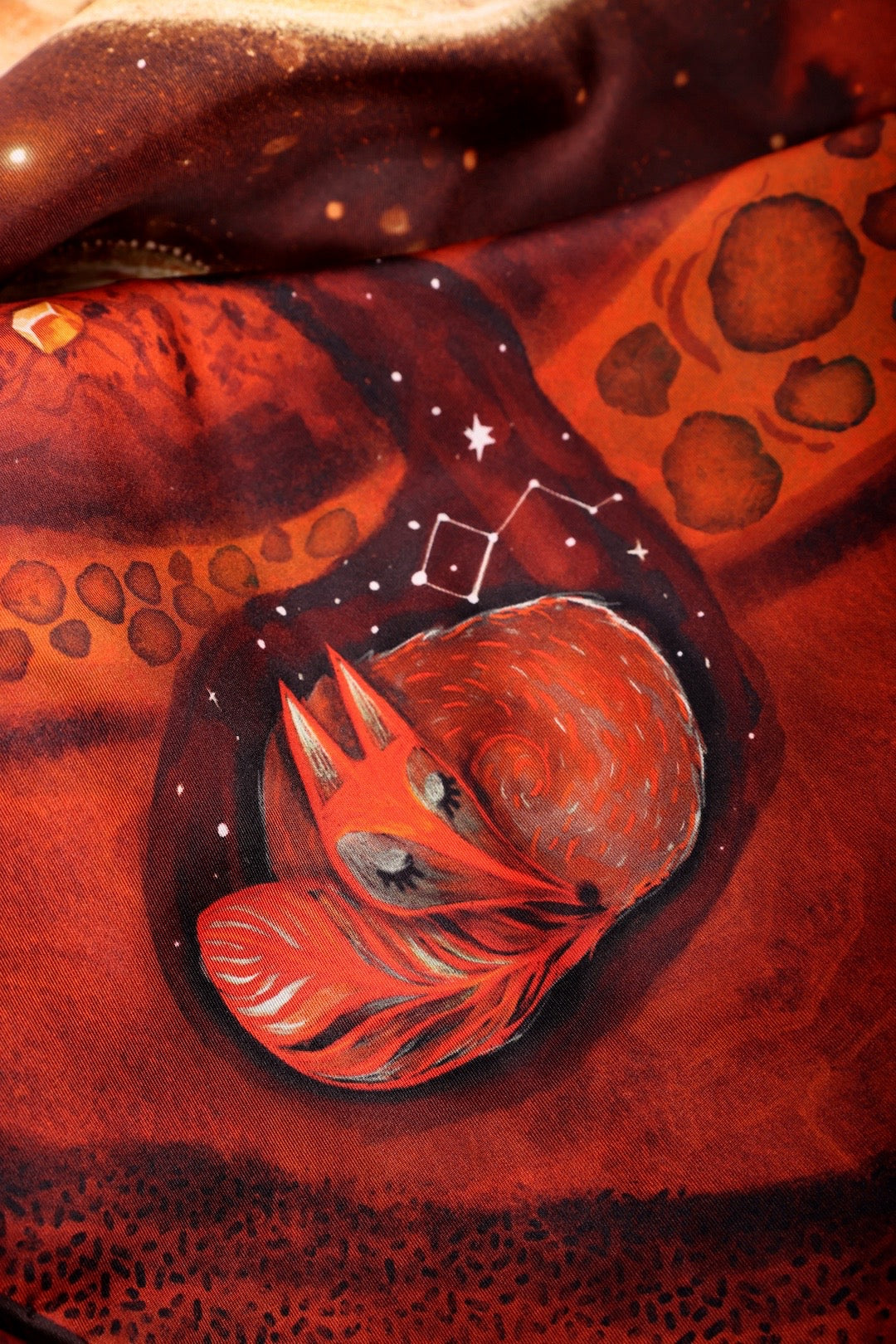 Detailed print of a sleeping fox and constellations on a luxury Journey of Yula silk scarf.