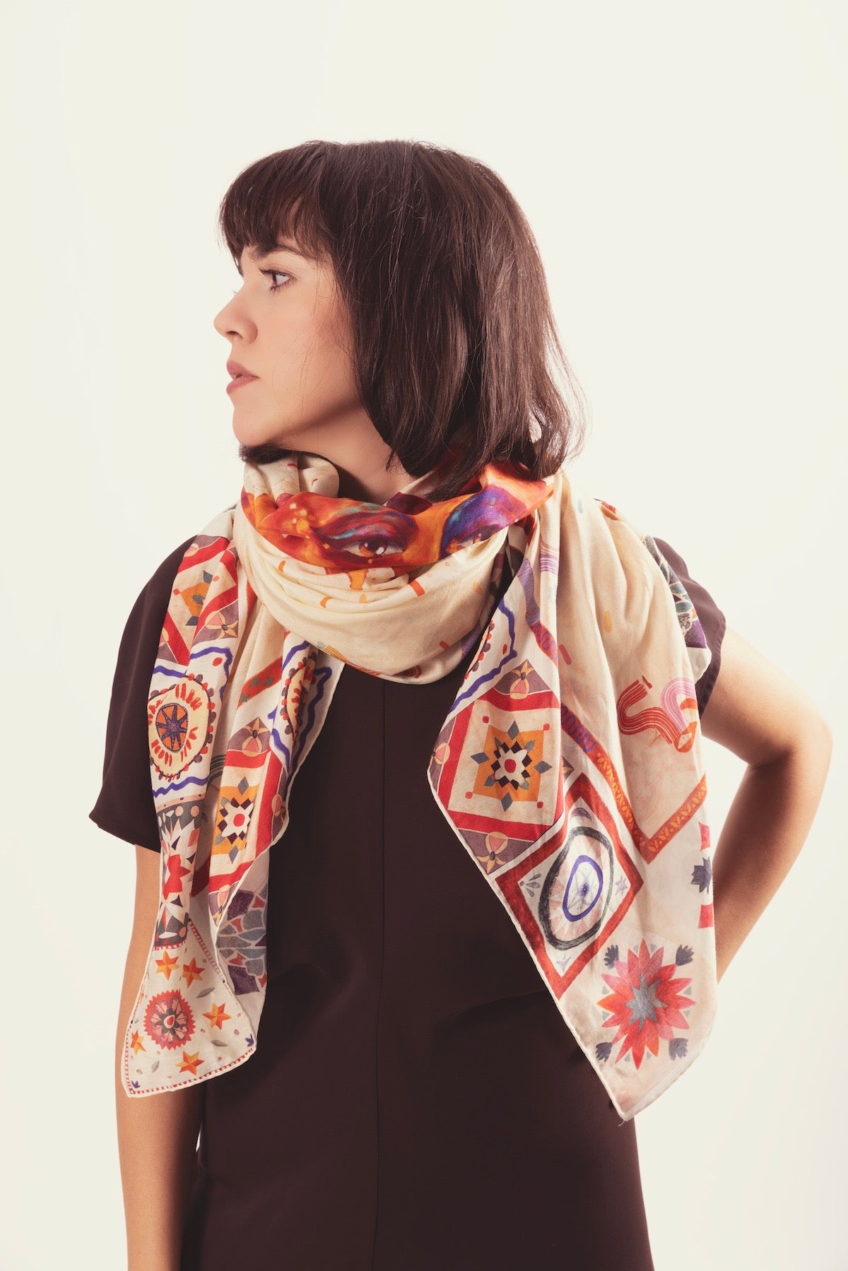 Journey of Yula luxury silk scarf with sun motif and ethnic borders displayed on a clean background.