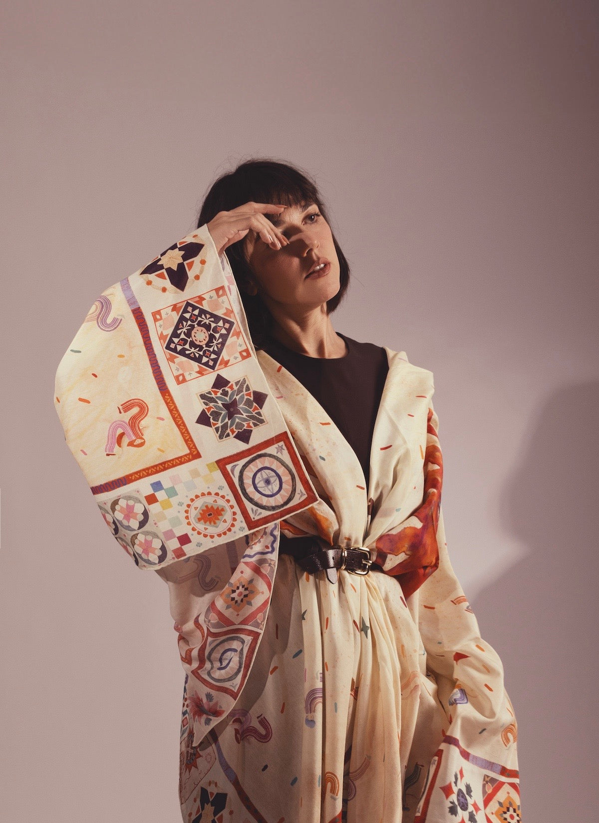 Artistic drape of a Journey of Yula silk scarf showcasing intricate geometric patterns and hand-drawn symbols.