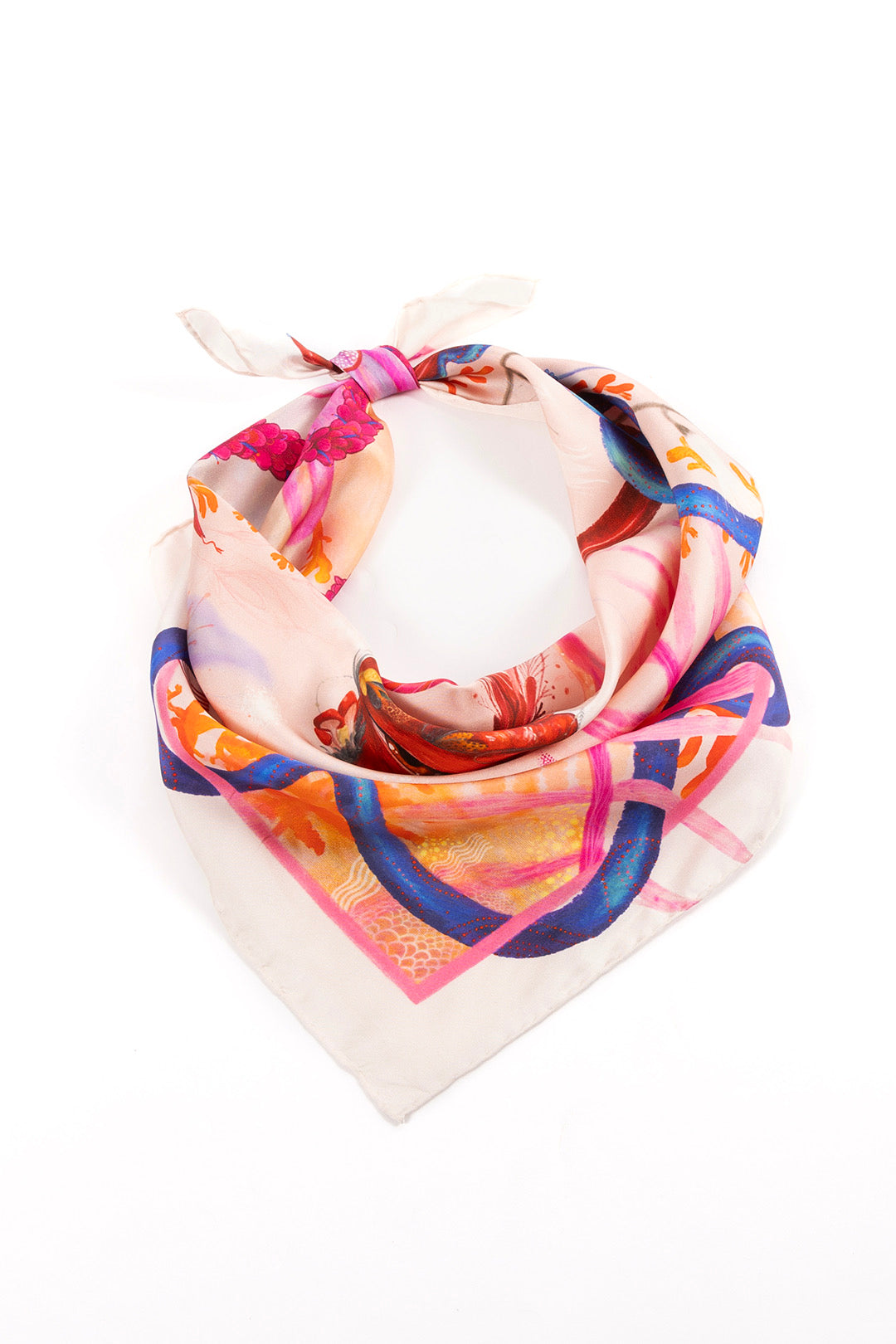 A high-angle product shot of the scarf loosely knotted on a white background, highlighting the blue coral motifs and the delicate pink border.